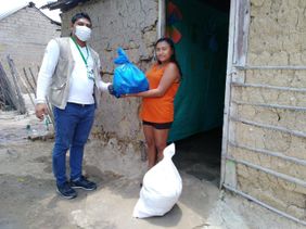 HIlfe in Not: Eine Frau bekommt von einem Helfer Lebensmittel und Hygieneartikel übergeben. Foto: Abiudea/Malteser