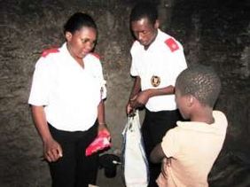 Two members of the care team speak with a boy during a home visit.