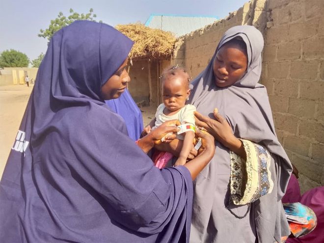 Zwei Frauen aus Nigeria halten einen Jungen