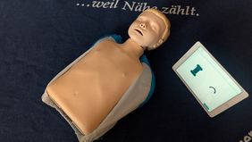 Eine Oberkörper-Übungspuppe der Malteser mit Tablet