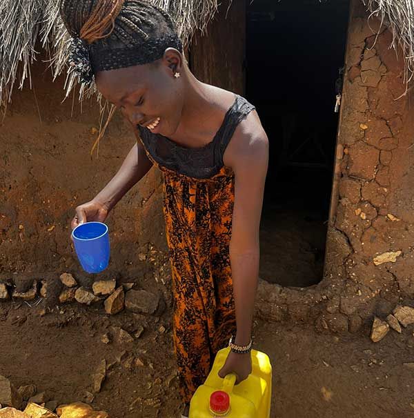Eine Frau mit Eimer und Wasserkanister 