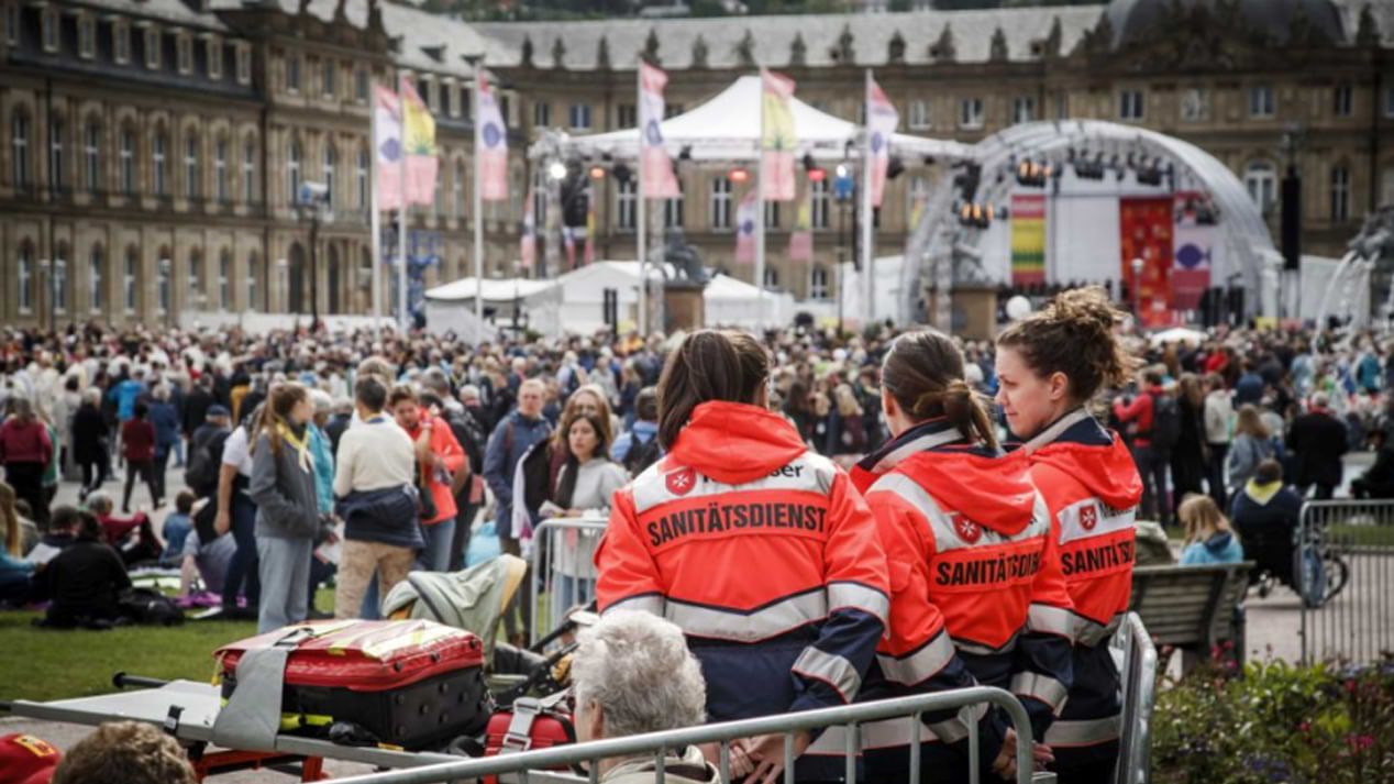 Drei Rettungssanitäterinnen stehen am Rande eines Großevents.