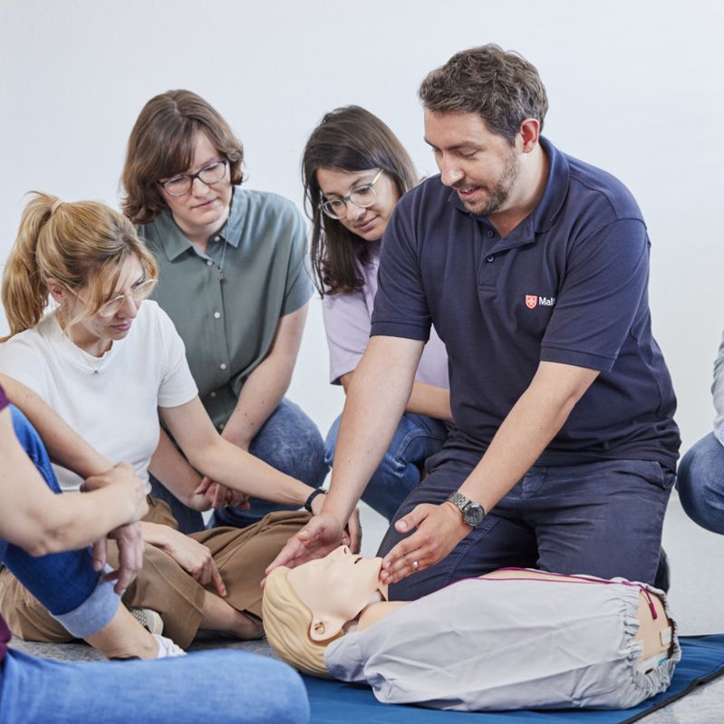 Ausbilder zeigt das Kopf-Überstrecken an einem Übungspahntom