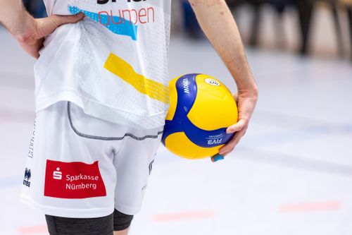 Volleyballspieler des SV Schwaig mit gelb-blauem Ball in der Hand, Trikot zeigt Sparkassenlogo auf der kurzen Hose.