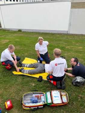 Die Teilnehmenden des Fortbildungswochenendes üben die Versorgung eines verunglückten Motorradfahrers