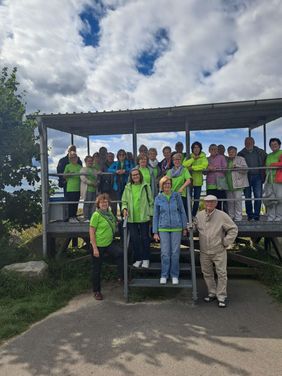 Viele Senioren stehen mit den Maltesern gemeinsam auf einem Gruppenbild zusammen. 