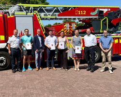 Vor einem Feuerwehrfahrzeug stehen die in ihre Funktionen berufenen Personen mit Vertretern von Stadt Mainz, Landkreis Mainz-Bingen und den Hilfsorganisationen
