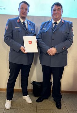 Andreas Töpfer und Matthias Lieske posieren in Malteser Dienstanzügen für das Foto