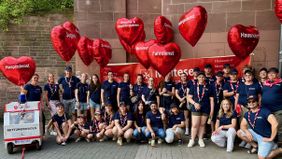 Gruppenbild ganz vieler Malteser mit roten Herz-Luftballons