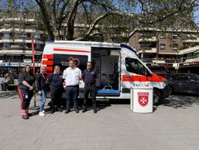 die beiden Stadtbeauftragten und drei ehrenamtliche Helfer stehen vor dem Herzenswunsch-Krankenwagen auf dem Spiel- und Sportwochenende in Oberhausen Strekrade