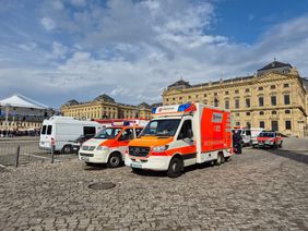 Mehrere Einsatzfahrzeuge der Malteser stehen vor der Würzburger Residenz