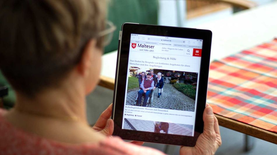 Frau liest am Tablet das Magazin dabei