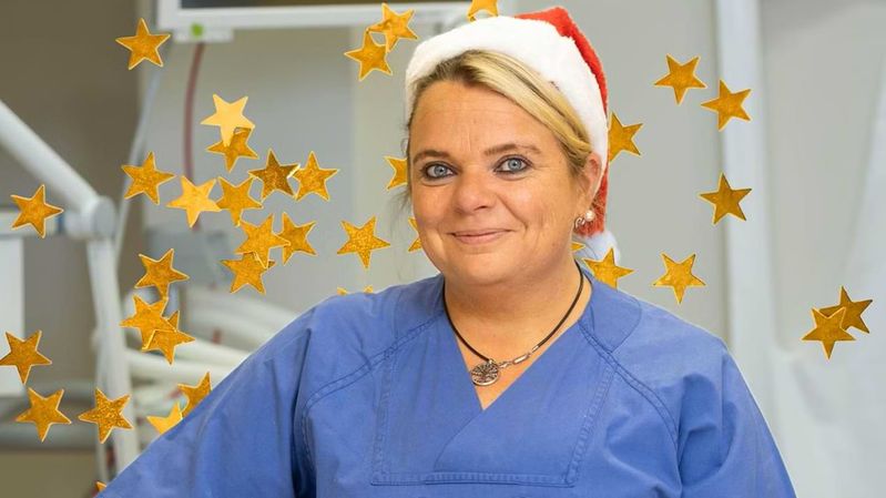 Eine lächelnde Pflegerin mit Weihnachtsmütze.