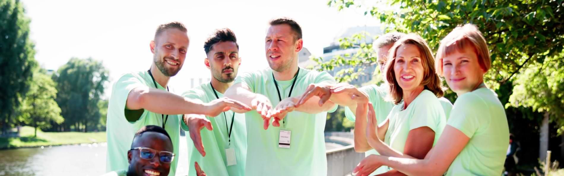 Eine Gruppe lachender Menschen mit grünen T-Shirts.