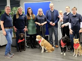 Alle Teams haben erfolgreich die Abschlussprüfung des Besuchs- und Begleitungsdienstes mit Hund der Malteser in Hennef bestanden, v.l.: Elke Wertenbruch, ehrenamtliche Leiterin des Dienstes mit Melanie Frieben und Labrador Mia; Trainerin Britta Gasparics; Miriam Müller und Hündin Nele; dem stellvertretenden Malteser Stadtbeauftragten Martin Rösler; Lisa Werner mit Tochter und Hündin Joy; Claudia Lange und Mischling Vio. 