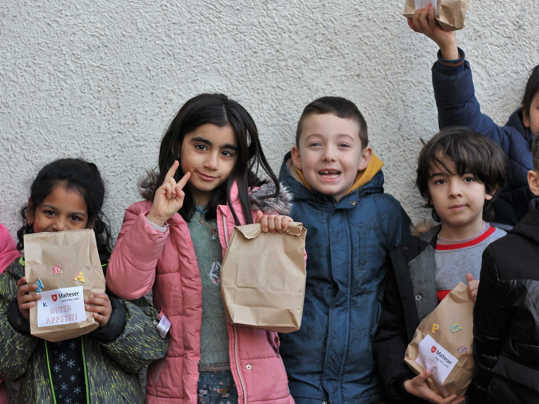 Gruppe von Kindern mit braunen Tüten