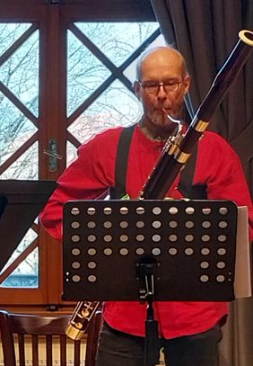 Martin Bandel steht vor einem Notenständer und spielt ein Musikinstrument.