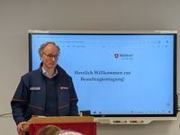 Diözesanleiter Dr. van Lengerich eröffnet die Tagung vor einem Smartboard das "Willkommen zur Beauftragtentagung" anzeigt