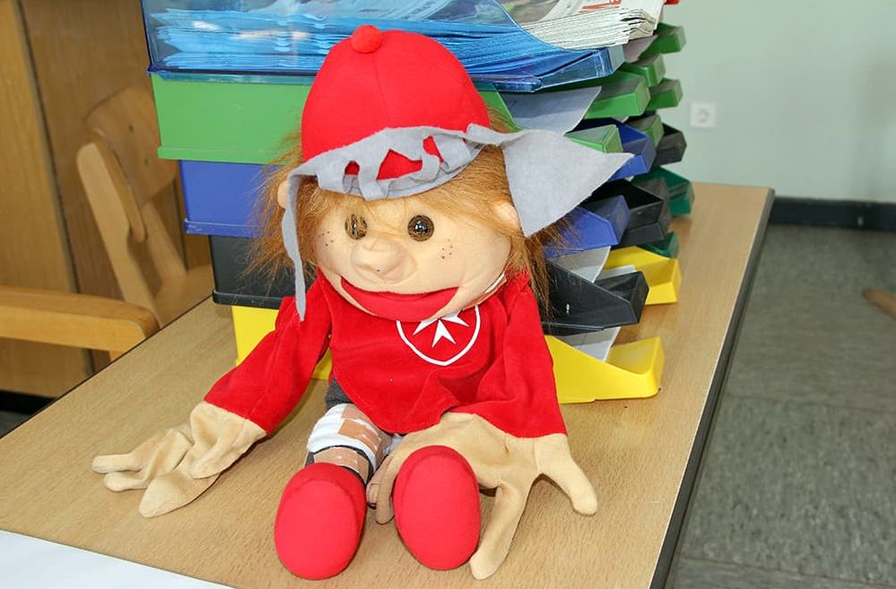 Handpuppe zum Thema Abenteuer helfen sitzt auf einem Tisch