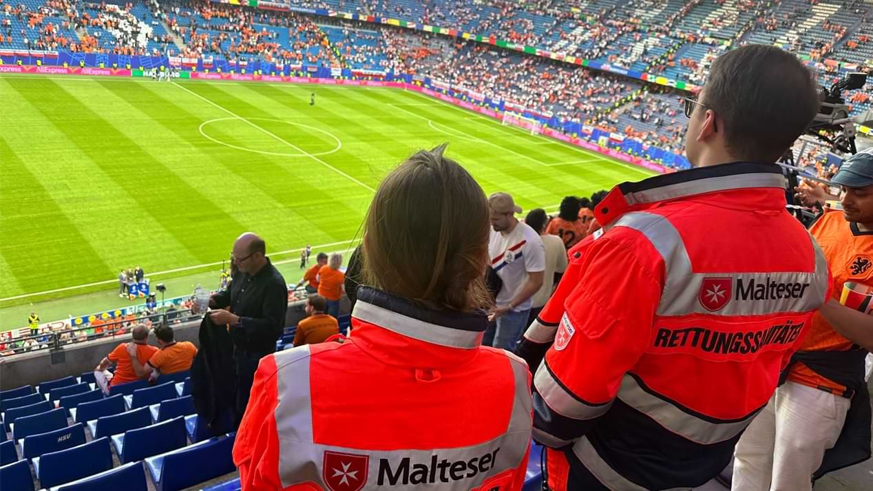 Zwei Menschen in Einsatzkleidung in einem Fußballstadion