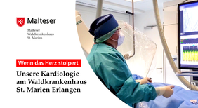 Kardiologe im OP-Saal blickt mit Haube und Maske auf Monitor.