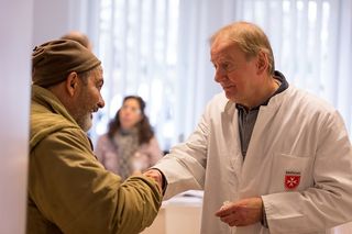 Ein Arzt begrüßt einen Mann mit Handschlag