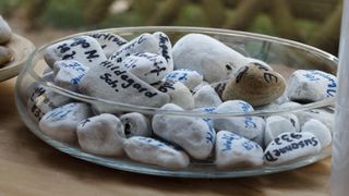 Schale mit bemalten Steinen zur Verabschiedung und Trauer.