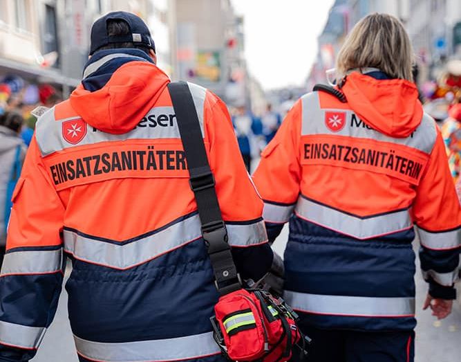 Zwei Rettungssanitäterinnen an Rosenmontag in Köln - von hinten aufgenommen. 