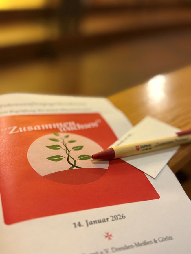 Das Liedheft mit Stift und Fürbittenkärtchen liegen auf einer Bank. Dies ist in der Christuskirche in Cottbus.