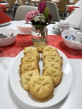 Plätzchen in Form des Malteser Wappens auf den Tischen