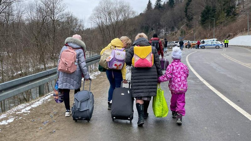 Eine kleine Gruppe Menschen mit Handgepäck auf einer Straße