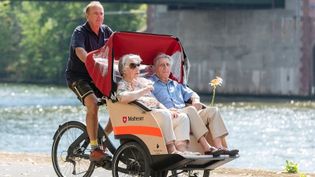Ein Seniorenpaar genießt eine Malteser Rikschafahrt in der Sonne.