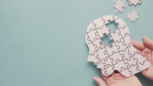 Die Silhouette eines Kopfes bestehend aus weißen Puzzleteilen.