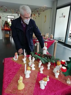 Malteser-Mitarbeiter richtet einen Adventstisch her.