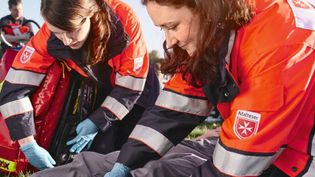 Mitarbeitendes des Malteser Sanitätsdienstes versorgen einen Verletzten bei einem Festival.
