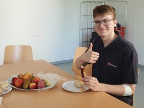 Ein junger Mann isst etwas, nachdem er Blut gespendet hat.