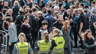 Eine Menschenmenge. Im Vodergrund die Polizei.