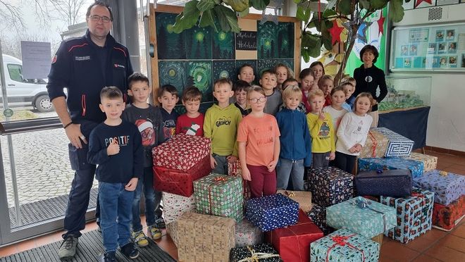 Schulkinder mit Pakaten, Schulleiterin Katharina Hornung und Malteser Kreisgeschäftsführer Roland Bucher