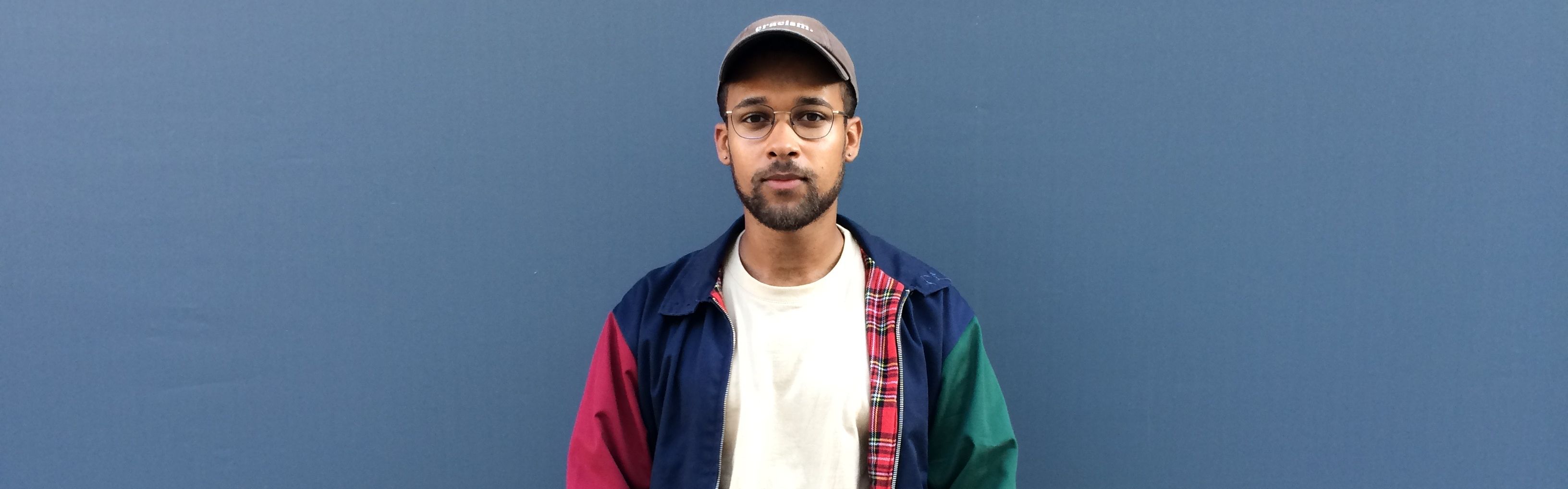 Portraitbild von David vor blauer Wand