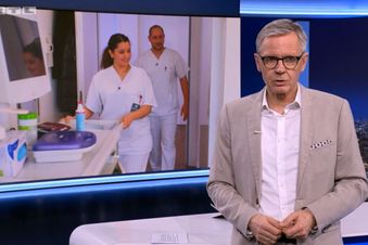 Nachrichtensprecher vor Bildschirm, auf dem Pflegende in Klinikflur gezeigt werden.