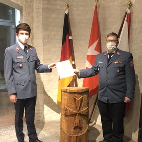 Malteser Ehrenamtlicher erhält feierlich eine Urkunde zur Berufung.