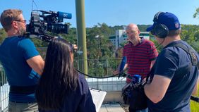 Kamerateam mit drei Personen filmt und interviewt einen Mann.