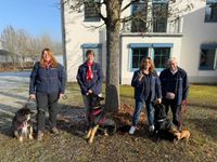 Vier Helferinnen des Besuchs- und Begleitungsdienstes stehen vor einem Gebäude mit jeweils einem Hund