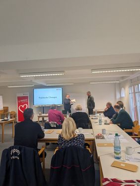 Zwei andere Teilnehmer üben Ehrungen im Rahmen eines kurzen Rollenspiels