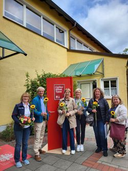 Ehrenamtliche der Trauergruppen der Malteser Twistringen und Alfhausen posieren mit Sonnenblumen.