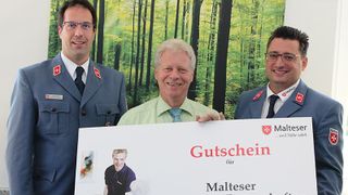 Gutschein Malteser Mahlzeitenpatenschaften wird überreicht.