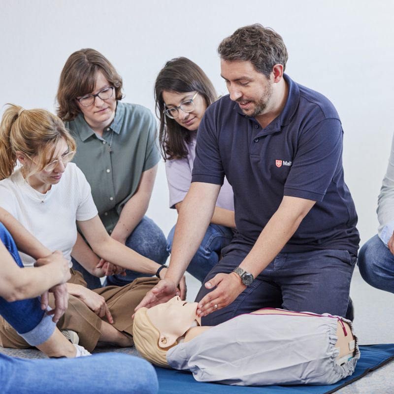 Ausbilder zeigt das Kopf-Überstrecken an einem Übungspahntom
