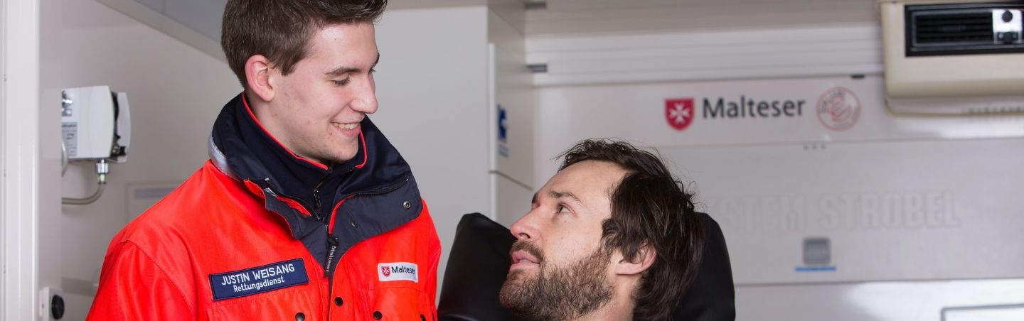 Junger Mann vom Rettungsdienst und ein Patient