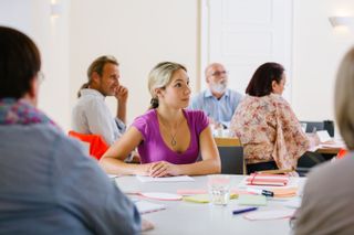 Seminargruppe an Tischen