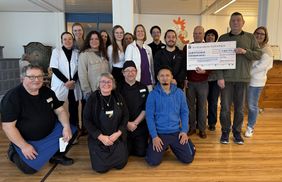 Gruppenbild mit vielen Menschen bei einer Scheckübergabe